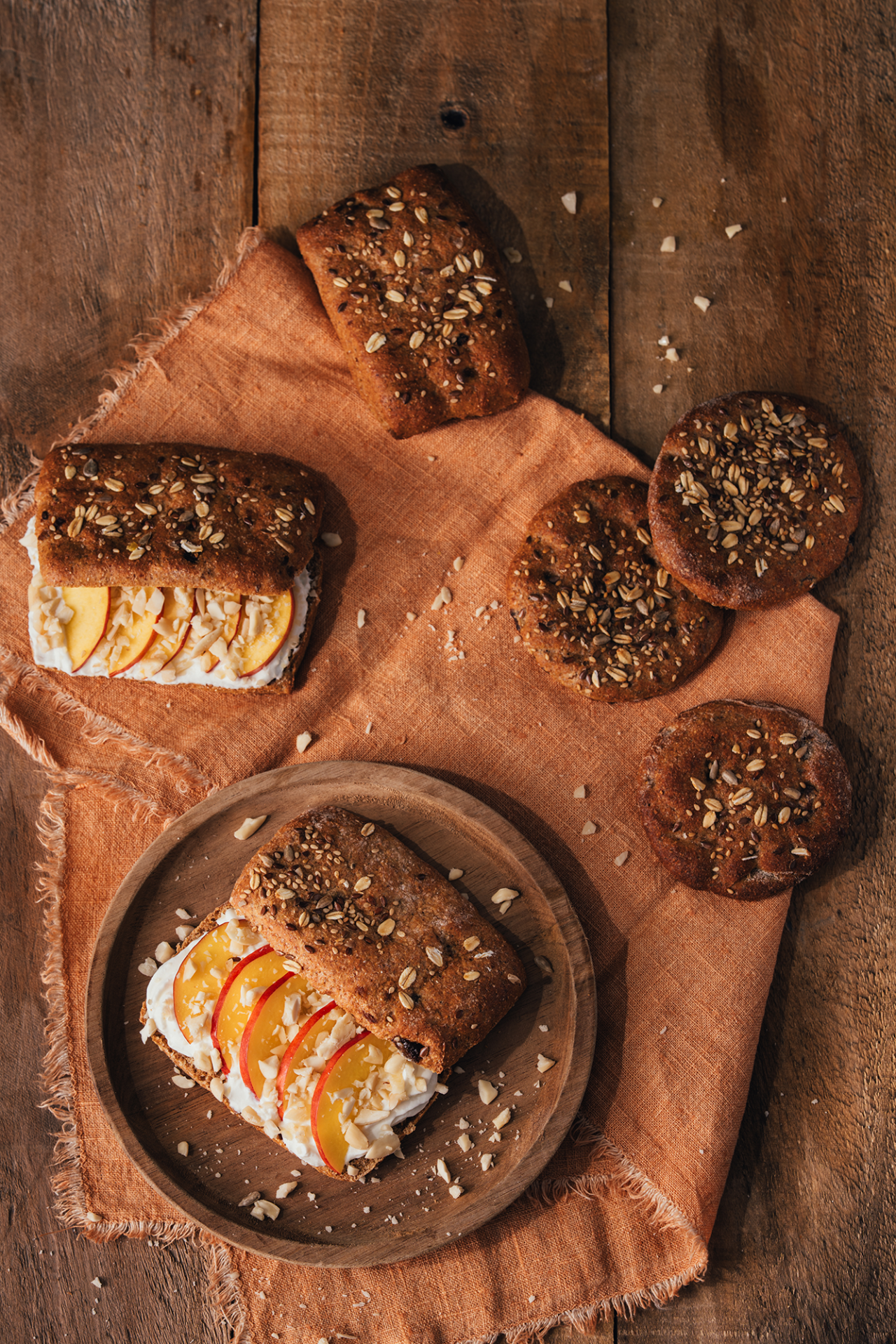 tavola imbandita con barrette di frutta e semi farcite con yogurt greco e pesca a fettina e cookies